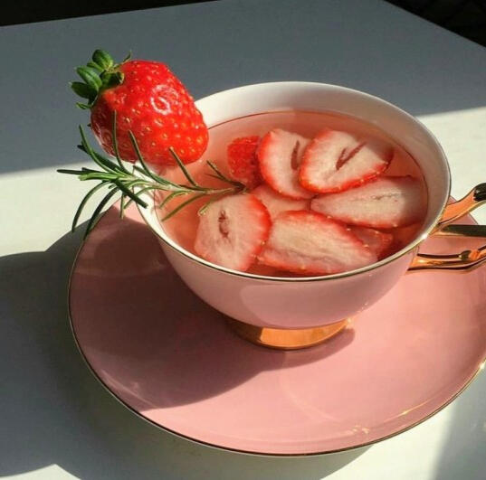 id: a teacup filled with strawberry slices